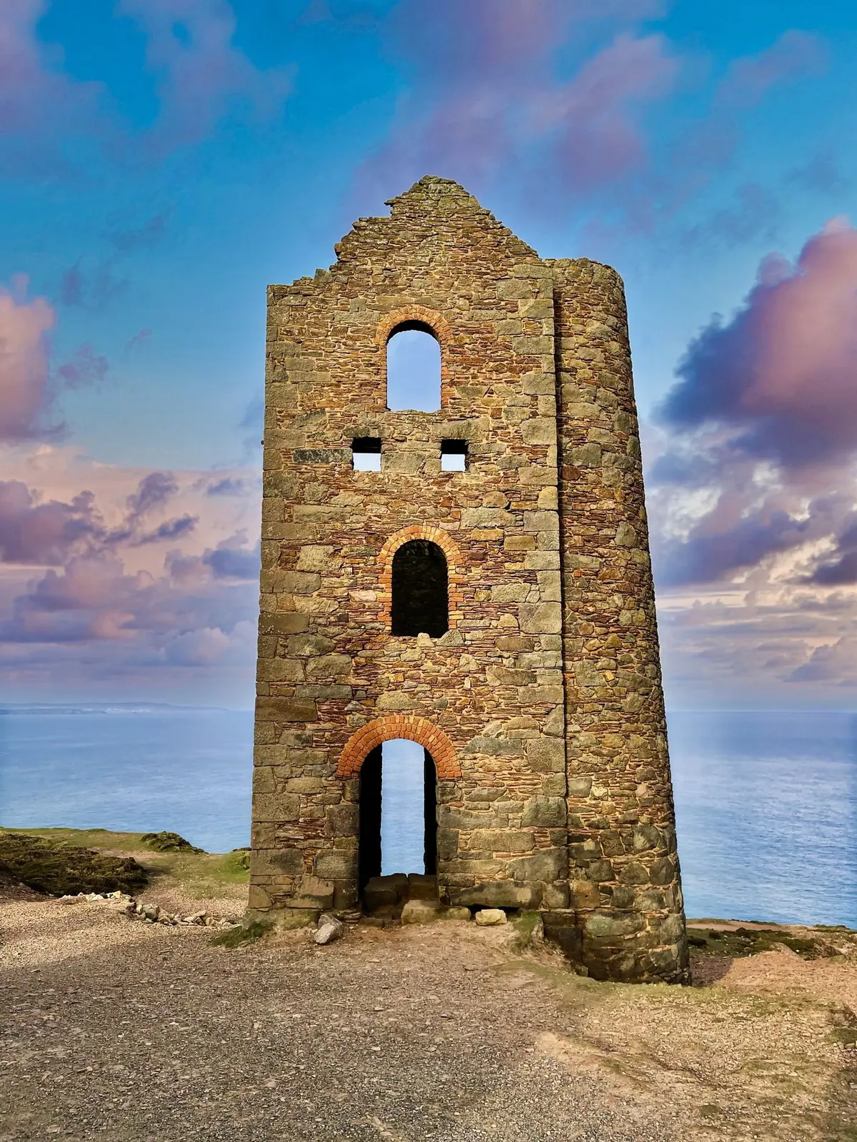A stone engine house against pink and blue evening cloud